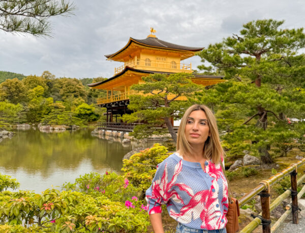 ragazza che sorride con alle spalle il padiglione d'oro di Kyoto